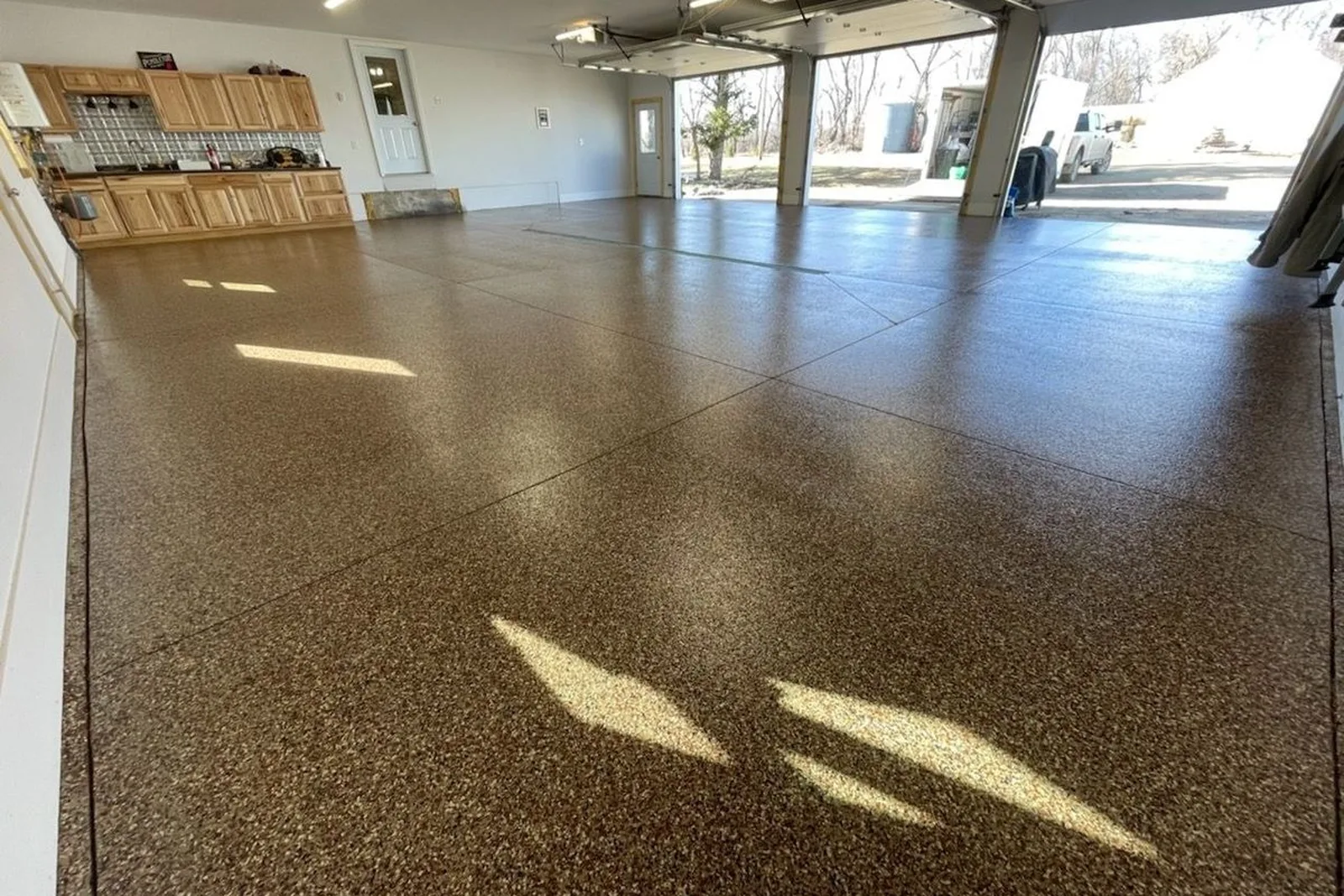 A finished epoxy flake garage floor, photographed after an install by Pegasus Surfaces, a coating company in Afton, Minnesota whose website Business Hub OS built